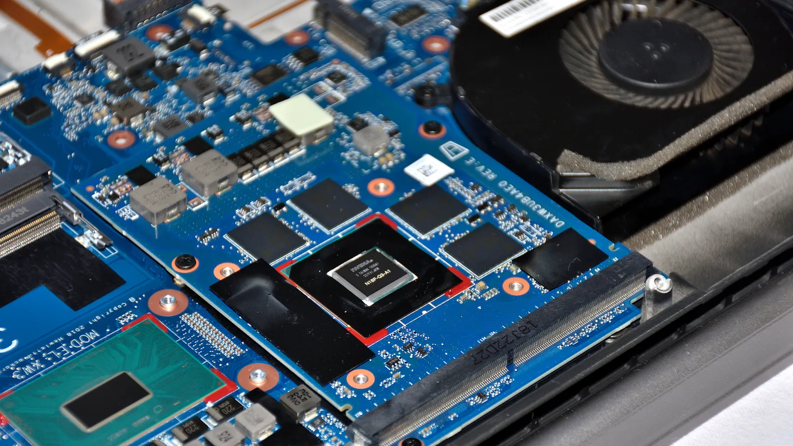 Close-up of an Nvidia MXM graphics module with its GPU chip and memory on a blue circuit board.