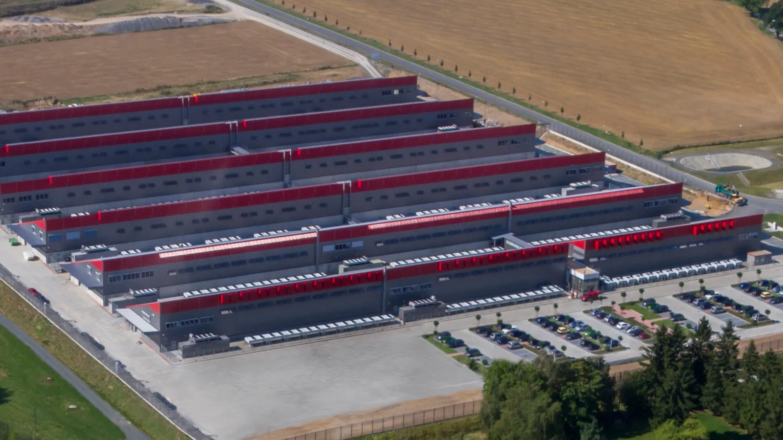 Aerial view of the Hetzner data center park in Falkenstein, long rows of red-roofed server halls.