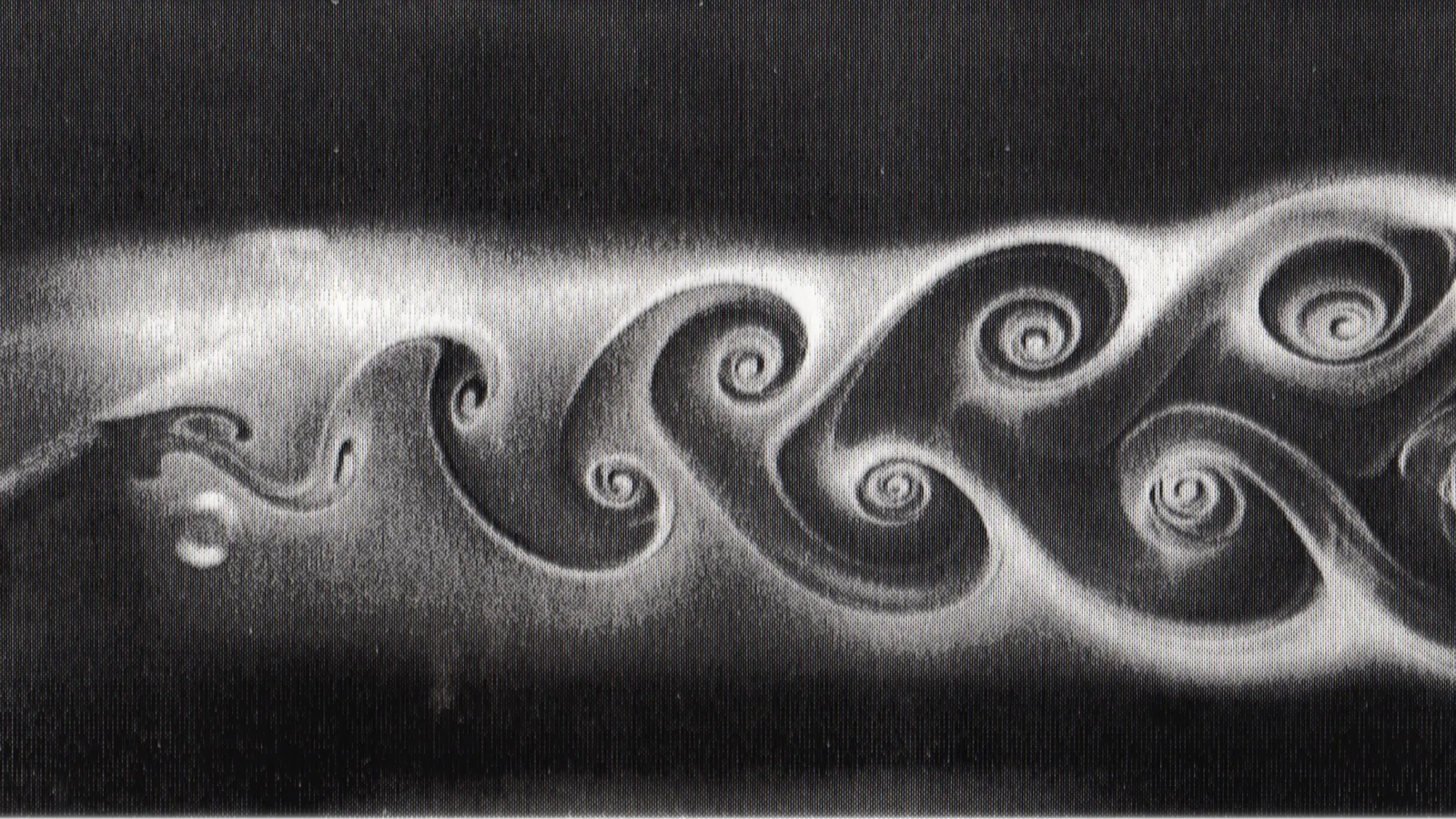 A black and white photo of a vortex street, swirling eddies shed by fluid flowing past an obstacle.