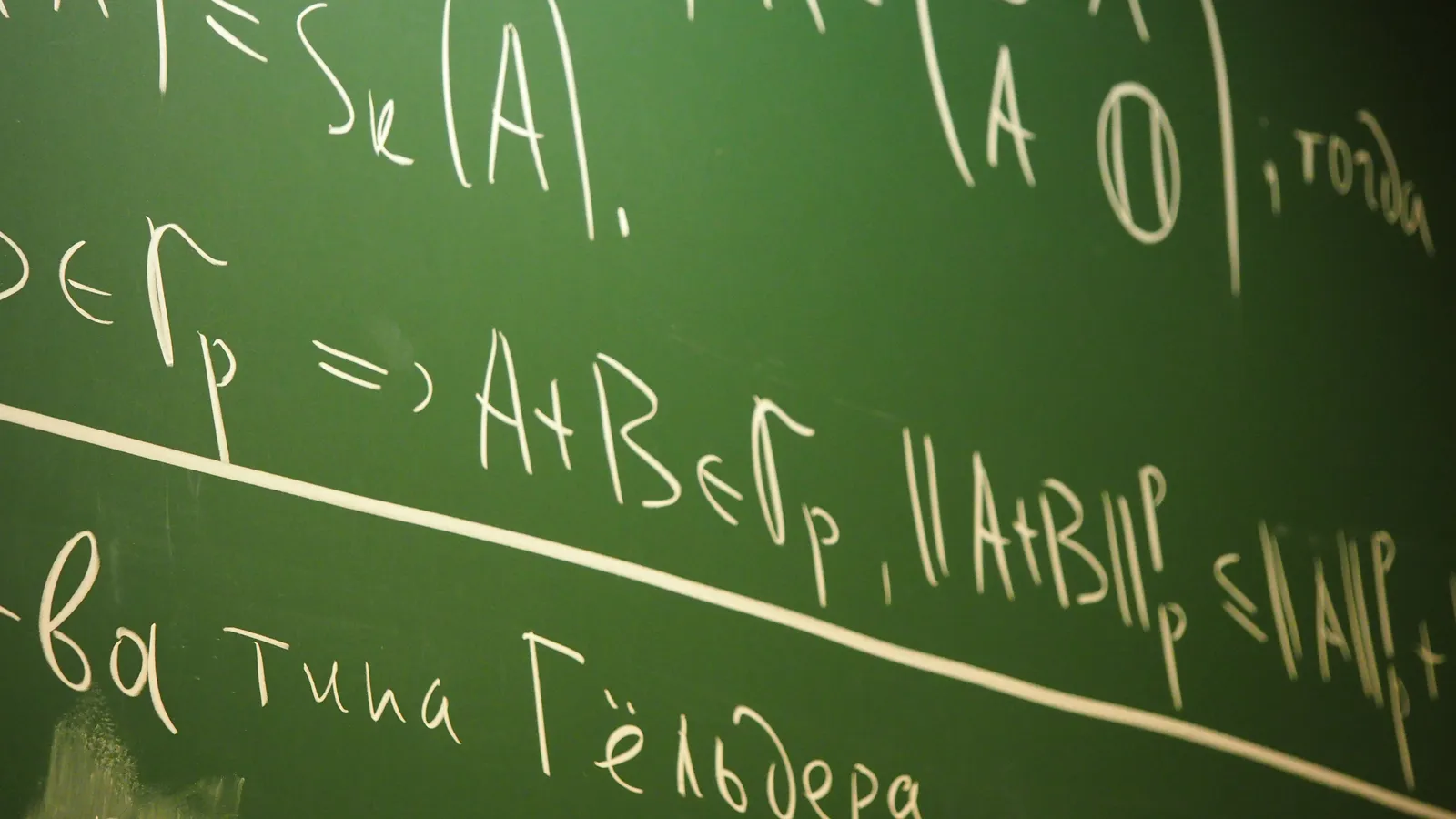A green chalkboard covered in handwritten research mathematics, matrices and inequalities in white chalk.